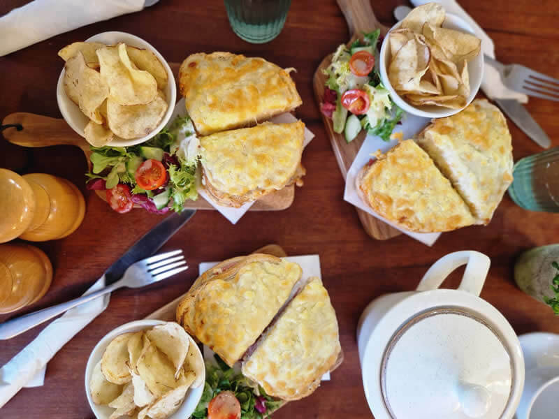 Hot cheese toasties with salad, potato crisps and hot beverages